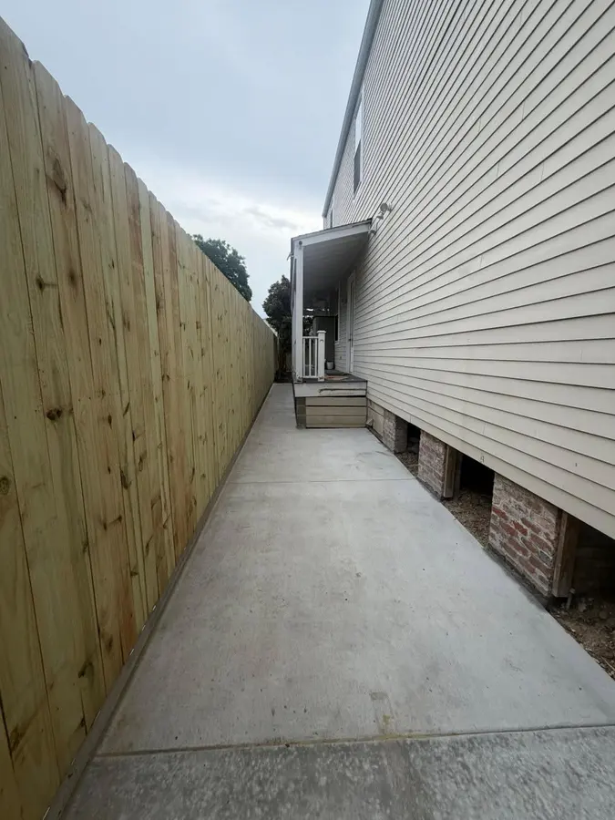 Pressure-treated pine privacy fence along a narrow side yard