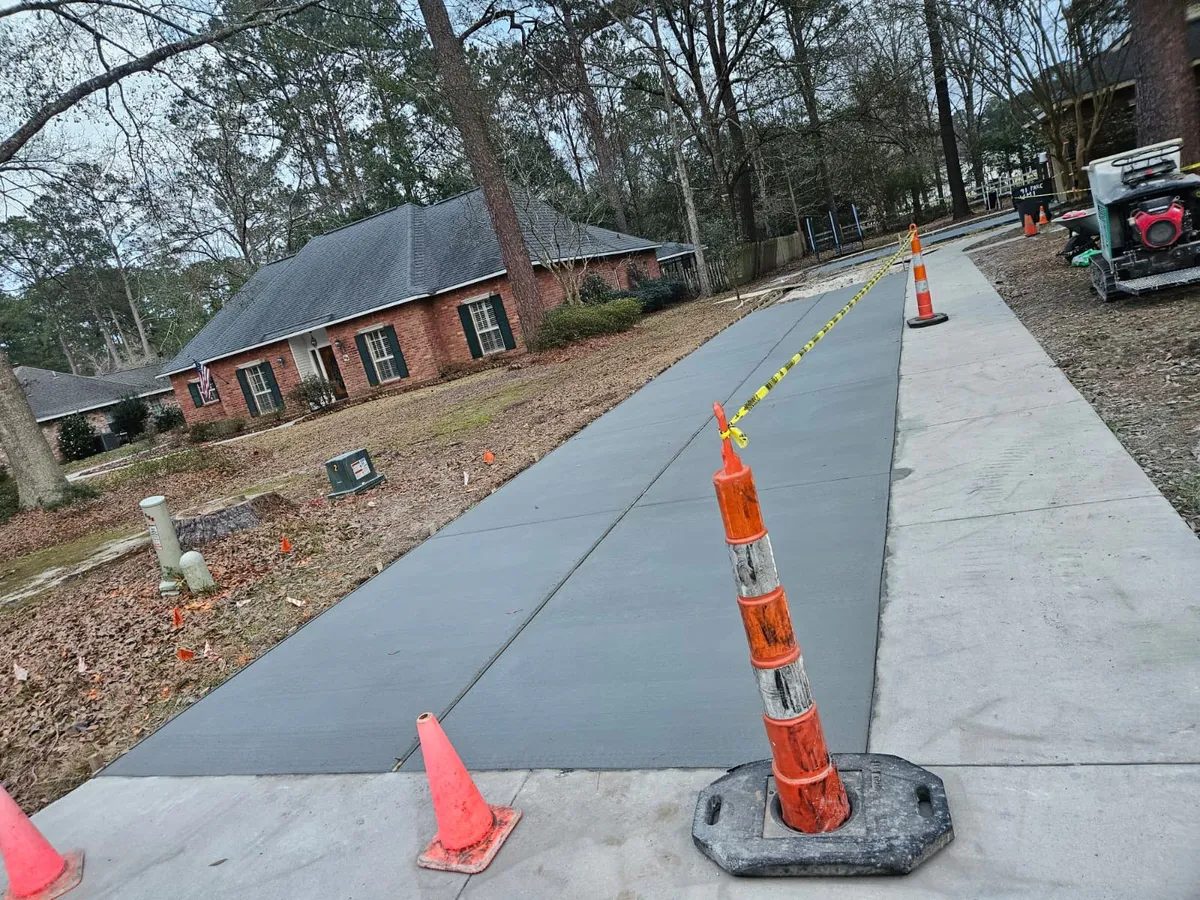 Freshly poured concrete driveway with safety cones at a Slidell residence