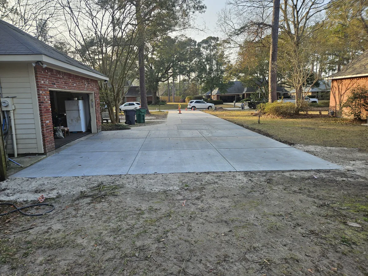 Large concrete driveway pad next to a residential garage