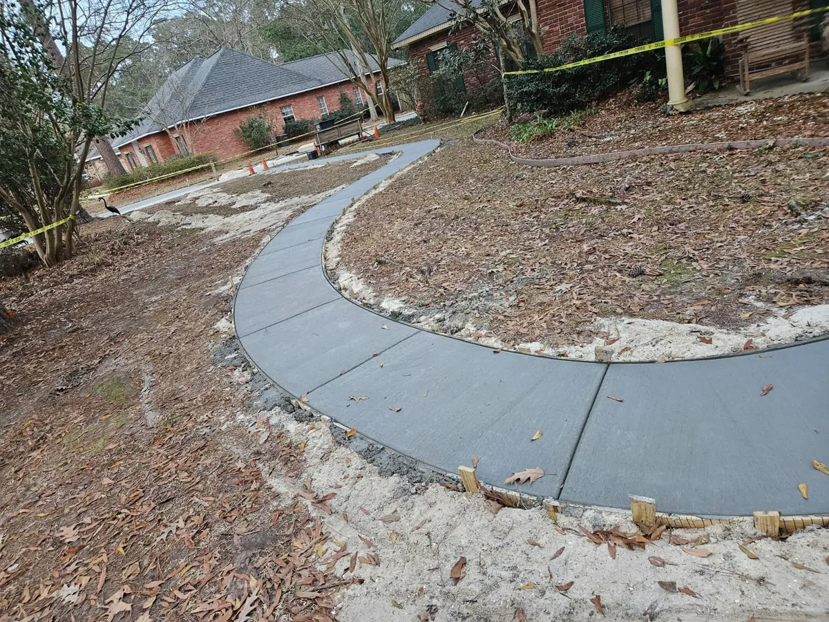 Completed concrete work surrounded by grass in residential yard