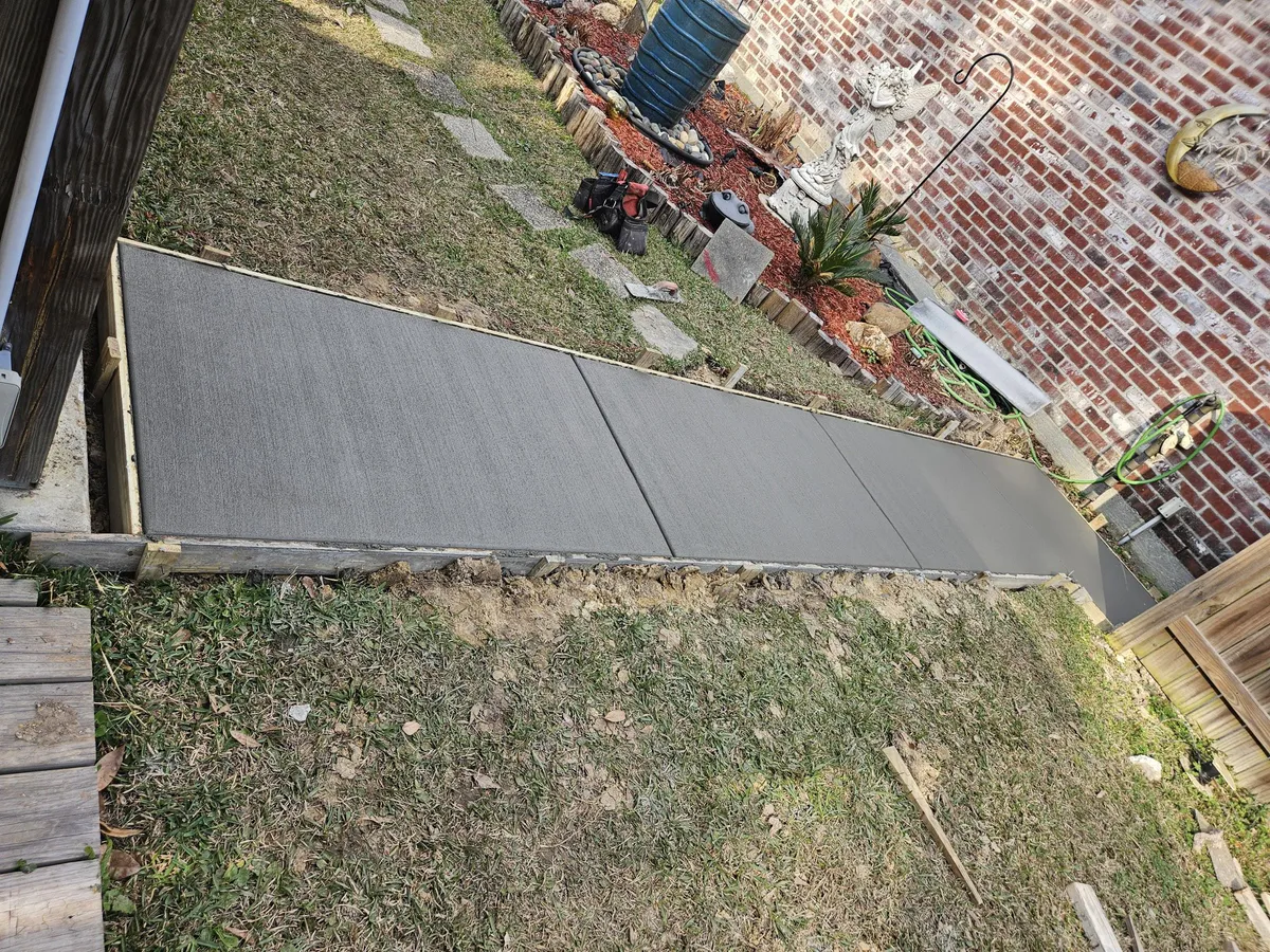 Concrete sidewalk poured along side of brick home