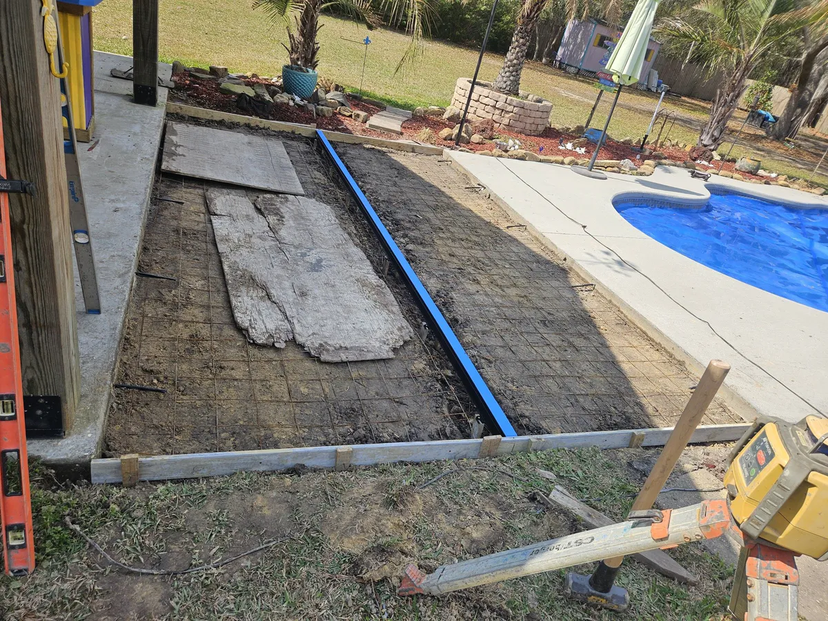 Concrete work next to outdoor structure on residential property