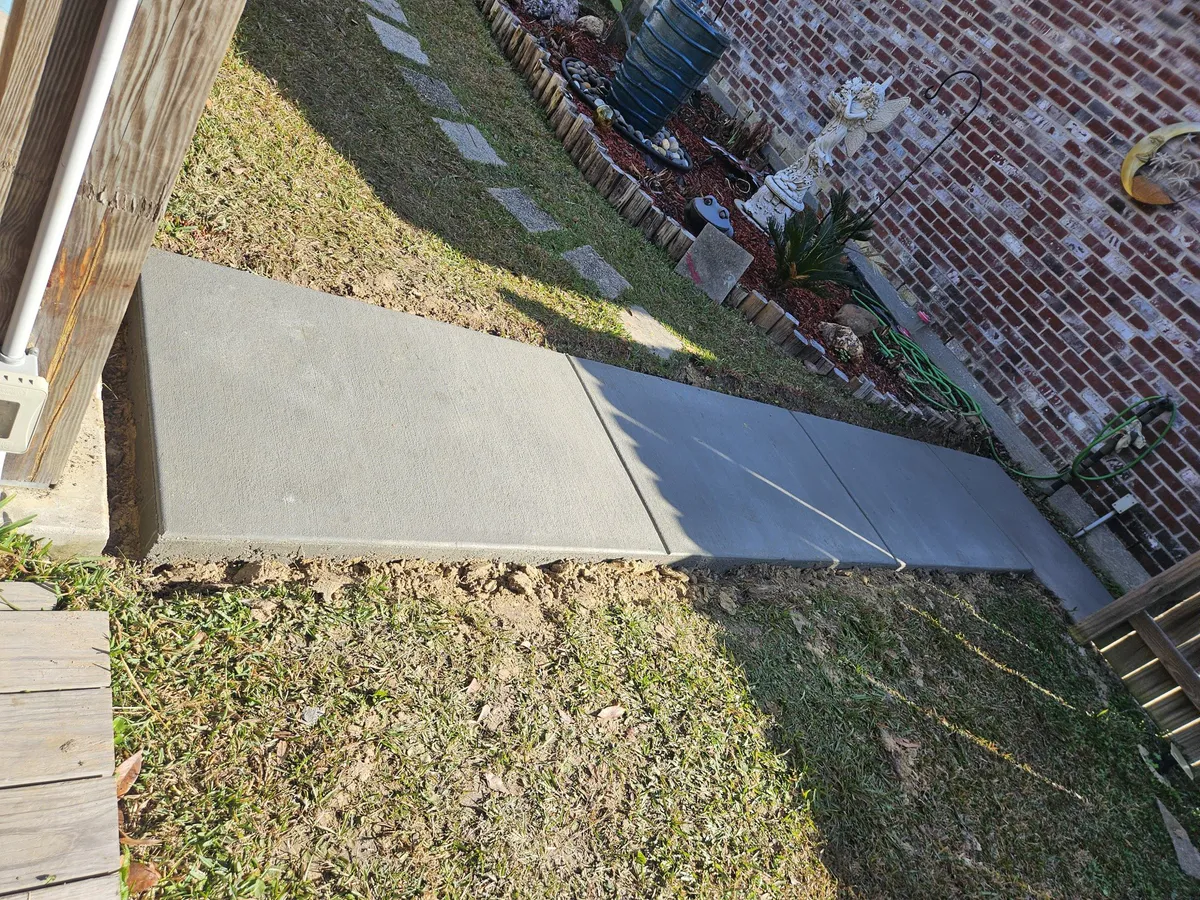 Concrete work in residential yard with surrounding grass